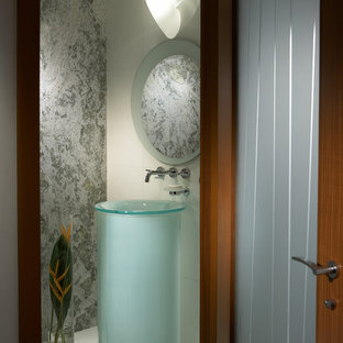 Small contemporary master bathroom in Miami with a vessel sink, medium wood cabinets, glass benchtops, a freestanding tub, a double shower, a one-piece toilet, white tile, grey walls and marble floors.