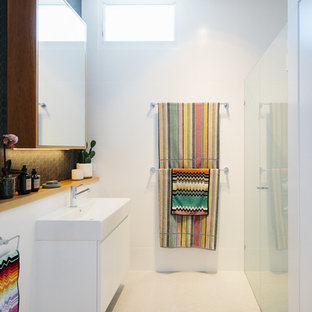 Contemporary bathroom in Other with flat-panel cabinets, white cabinets, a curbless shower, white tile, white walls, a console sink, white floor and a hinged shower door.
