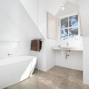 Transitional master bathroom in Sydney with flat-panel cabinets, light wood cabinets, a freestanding tub, an open shower, white tile, porcelain tile, white walls, travertine floors, a wall-mount sink, an open shower, white benchtops and beige floor.