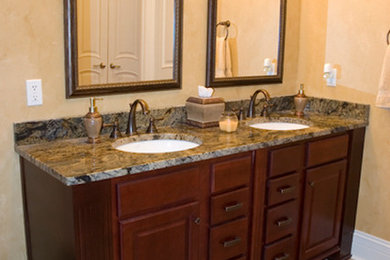 Bathroom - large traditional beige tile and ceramic tile ceramic tile bathroom idea in Cincinnati with a console sink, raised-panel cabinets, dark wood cabinets, granite countertops and beige walls