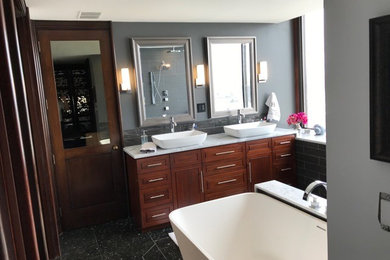 Bathroom - large transitional master gray tile and porcelain tile porcelain tile and black floor bathroom idea in Salt Lake City with beaded inset cabinets, dark wood cabinets, gray walls, a vessel sink and marble countertops