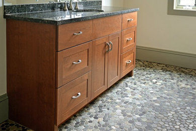 Example of a mid-sized transitional pebble tile floor bathroom design in Other with an undermount sink, shaker cabinets, medium tone wood cabinets, granite countertops and beige walls