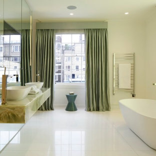 Design ideas for a large contemporary bathroom in London with a freestanding bath, mirror tiles, a vessel sink, white floors, white walls and green worktops.