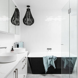 Design ideas for a contemporary bathroom in Hobart with flat-panel cabinets, white cabinets, a freestanding tub, white walls, a vessel sink, grey floor, white benchtops and a double vanity.