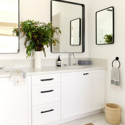 Example of a mid-sized trendy master marble floor, white floor and double-sink freestanding bathtub design in Los Angeles with white cabinets, white walls and a built-in vanity