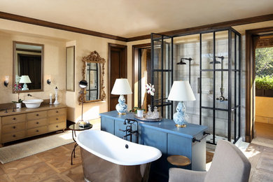 Inredning av ett medelhavsstil en-suite badrum, med skåp i mellenmörkt trä, ett fristående badkar, en dubbeldusch, beige väggar, ett fristående handfat, träbänkskiva, beiget golv, dusch med gångjärnsdörr och släta luckor