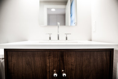 Diseño de cuarto de baño de estilo americano de tamaño medio con suelo de madera en tonos medios, suelo marrón, armarios tipo mueble, puertas de armario de madera en tonos medios y encimeras blancas