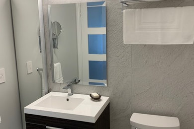 Example of a small minimalist 3/4 gray tile and stone tile bathroom design in Ottawa with flat-panel cabinets, dark wood cabinets, an integrated sink, solid surface countertops and white countertops