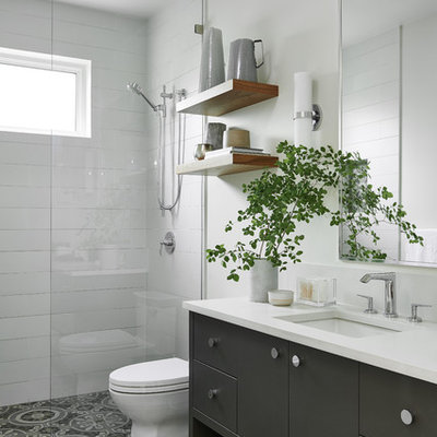 Bathroom - mid-sized contemporary 3/4 cement tile floor and gray floor bathroom idea in Vancouver with furniture-like cabinets, gray cabinets, a one-piece toilet, white walls, a vessel sink, quartzite countertops and white countertops