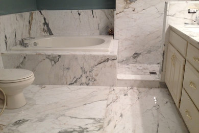 Small elegant master white tile and stone slab marble floor bathroom photo in Los Angeles with marble countertops, raised-panel cabinets and white cabinets