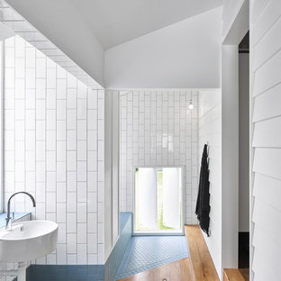 Beach style bathroom in Brisbane with blue tile, white tile, subway tile, white walls, a wall-mount sink and vaulted.