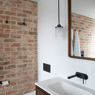 Inspiration for a contemporary bathroom in Sydney with flat-panel cabinets, dark wood cabinets, a wall-mount toilet, white walls, a console sink and grey floor.
