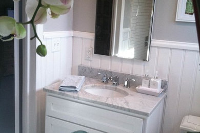 Photo of a classic bathroom in Columbus with a submerged sink, a double shower, a two-piece toilet, raised-panel cabinets, white cabinets, marble worktops, white tiles and metro tiles.