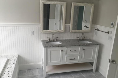 Example of a mid-sized classic master gray tile bathroom design in Other with recessed-panel cabinets, white cabinets, a one-piece toilet, gray walls, an undermount sink and granite countertops