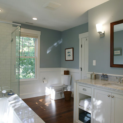 Corner shower - mid-sized traditional master white tile and ceramic tile dark wood floor corner shower idea in Boston with white cabinets, an undermount tub, a two-piece toilet, blue walls, an undermount sink, marble countertops and beaded inset cabinets