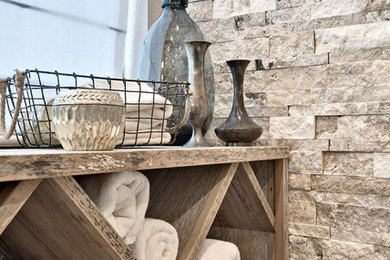 Bathroom - mid-sized transitional master gray tile and travertine tile ceramic tile bathroom idea in Austin with furniture-like cabinets, light wood cabinets, white walls, an undermount sink, quartz countertops and a hinged shower door