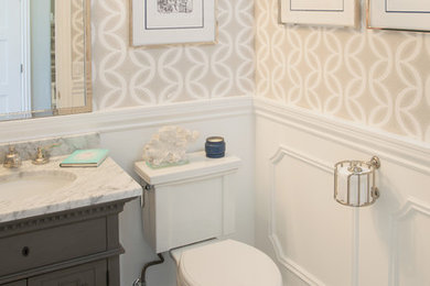 Klassisches Badezimmer mit grauen Schränken, Wandtoilette mit Spülkasten, beiger Wandfarbe, Unterbauwaschbecken und Schrankfronten mit vertiefter Füllung in San Diego
