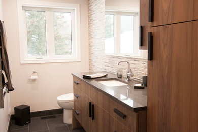 Mid-sized minimalist master white tile and porcelain tile porcelain tile and black floor double shower photo in Ottawa with flat-panel cabinets, dark wood cabinets, a bidet, gray walls, an undermount sink, solid surface countertops, a hinged shower door and gray countertops