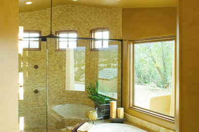 アルバカーキにある高級な中くらいな地中海スタイルのおしゃれなマスターバスルーム (ドロップイン型浴槽、黄色いタイル、石タイル、ベージュの壁) の写真