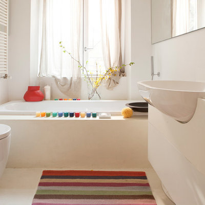 Small trendy drop-in bathtub photo in Milan with flat-panel cabinets, white cabinets, a one-piece toilet, white walls and a drop-in sink