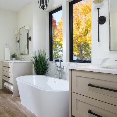 Example of a transitional master wood-look tile floor, brown floor and double-sink freestanding bathtub design in Minneapolis with shaker cabinets, beige cabinets, white walls, quartz countertops, white countertops and a built-in vanity