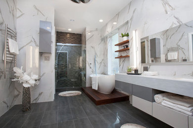 Inspiration for a large contemporary master gray tile and porcelain tile porcelain tile bathroom remodel in Dallas with flat-panel cabinets, white cabinets, a hot tub, a one-piece toilet, a drop-in sink, limestone countertops and white walls
