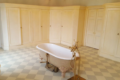 Foto de cuarto de baño infantil clásico grande con armarios estilo shaker, bañera con patas, sanitario de una pieza, baldosas y/o azulejos beige, paredes beige y suelo vinílico