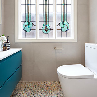 Idée de décoration pour une petit salle de bain principale design avec des portes de placards vertess, un combiné douche/baignoire, un WC suspendu, un carrelage beige, un sol en terrazzo, une cabine de douche à porte battante, un plan de toilette blanc, un placard en trompe-l'oeil, une baignoire posée, un carrelage de pierre, un mur beige, une vasque, un plan de toilette en quartz modifié et un sol multicolore.