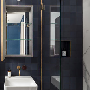 Photo of a contemporary ensuite bathroom in London with a walk-in shower, blue tiles, cement tiles, a wall-mounted sink, a hinged door, a single sink and a wall niche.