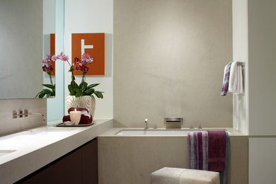 Example of a large trendy master japanese bathtub design in New York with flat-panel cabinets, dark wood cabinets, white walls, an undermount sink and solid surface countertops