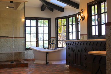 На фото: огромная главная ванная комната в средиземноморском стиле с врезной раковиной, фасадами с утопленной филенкой, темными деревянными фасадами, мраморной столешницей, отдельно стоящей ванной, раздельным унитазом, разноцветной плиткой, терракотовой плиткой и белыми стенами