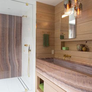 Modern inredning av ett mellanstort brun brunt en-suite badrum, med släta luckor, skåp i mellenmörkt trä, en dusch i en alkov, ett avlångt handfat, vitt golv, brun kakel, flerfärgad kakel, stenhäll, klinkergolv i keramik, bänkskiva i onyx och dusch med gångjärnsdörr