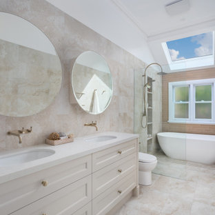 Inspiration for an expansive transitional bathroom in Perth with shaker cabinets, a freestanding tub, an open shower, a two-piece toilet, travertine, an undermount sink, engineered quartz benchtops, an open shower, white benchtops, a double vanity, a freestanding vanity, beige walls, beige floor and a niche.