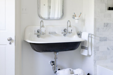 Bild på ett litet vintage vit vitt badrum för barn, med öppna hyllor, svarta skåp, ett badkar i en alkov, en dusch/badkar-kombination, en toalettstol med separat cisternkåpa, vit kakel, marmorkakel, vita väggar, marmorgolv, ett avlångt handfat och dusch med duschdraperi