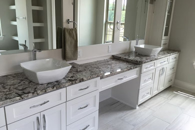 Design ideas for a large classic ensuite bathroom in Austin with shaker cabinets, white cabinets, a freestanding bath, beige walls, porcelain flooring, a vessel sink, granite worktops and beige floors.