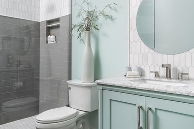Photo of a coastal shower room bathroom in Atlanta with green cabinets, a two-piece toilet, grey tiles, white tiles, green walls, a submerged sink, grey floors, white worktops and shaker cabinets.