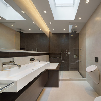 Mid-sized minimalist master porcelain tile porcelain tile doorless shower photo in New York with a wall-mount sink, flat-panel cabinets, dark wood cabinets, an undermount tub, a wall-mount toilet and gray walls