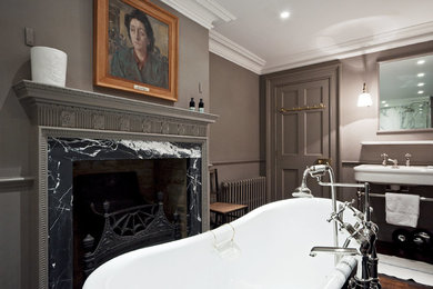 This is an example of a victorian bathroom in London with a freestanding bath, a shower/bath combination and a chimney breast.