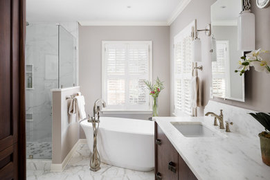 Mid-sized transitional master white tile and porcelain tile marble floor and white floor bathroom photo in Louisville with flat-panel cabinets, medium tone wood cabinets, a two-piece toilet, gray walls, an undermount sink, marble countertops, a hinged shower door and white countertops