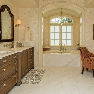 Alcove bathtub - large traditional master porcelain tile and white floor alcove bathtub idea in Denver with recessed-panel cabinets, dark wood cabinets, a one-piece toilet, beige walls, an integrated sink and marble countertops