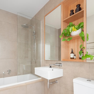Example of a mid-sized trendy beige tile beige floor bathroom design in Melbourne with a wall-mount sink, a two-piece toilet and beige walls
