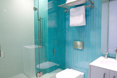 Inspiration for a small modern 3/4 blue tile and glass tile porcelain tile alcove shower remodel in Los Angeles with flat-panel cabinets, white cabinets, a wall-mount toilet, blue walls, an undermount sink and quartz countertops
