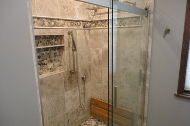 シカゴにある中くらいなコンテンポラリースタイルのおしゃれなバスルーム (浴槽なし) (コーナー設置型シャワー、ベージュのタイル、セラミックタイル、グレーの壁、玉石タイル、茶色い床、引戸のシャワー) の写真