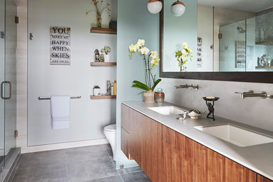 Example of a mid-sized trendy master gray tile and porcelain tile cement tile floor and gray floor bathroom design in Chicago with flat-panel cabinets, medium tone wood cabinets, a one-piece toilet, gray walls, an undermount sink, concrete countertops, a hinged shower door and gray countertops