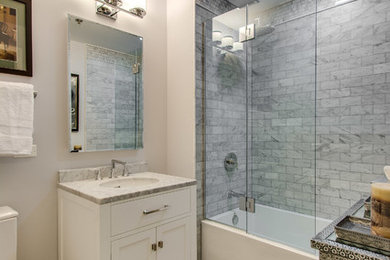 Example of a mid-sized minimalist gray tile and stone slab marble floor bathroom design in Chicago with an undermount sink, flat-panel cabinets, white cabinets, marble countertops, a two-piece toilet and gray walls