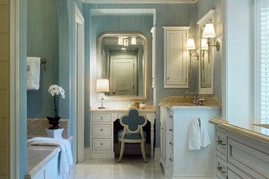 Réalisation d'une grande salle de bain principale tradition avec un lavabo encastré, un plan de toilette en granite, un sol en marbre, un placard avec porte à panneau encastré, des portes de placard blanches, une baignoire en alcôve, un carrelage beige, un carrelage blanc, des carreaux de céramique et un mur bleu.