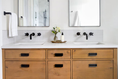 Example of a large transitional master white tile gray floor and porcelain tile freestanding bathtub design in Calgary with flat-panel cabinets, medium tone wood cabinets, white walls, an undermount sink, white countertops and quartz countertops