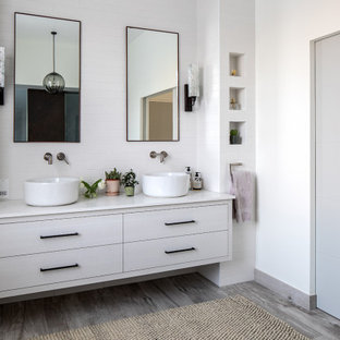 Photo of a contemporary bathroom in London with flat-panel cabinets, grey cabinets, white tiles, metro tiles, white walls, a vessel sink, grey floors, white worktops, double sinks and a floating vanity unit.