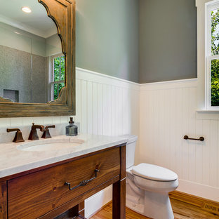 Example of a cottage medium tone wood floor bathroom design in Charlotte with an undermount sink, furniture-like cabinets, medium tone wood cabinets, green walls and a two-piece toilet