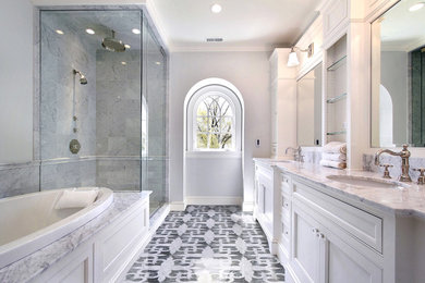 Стильный дизайн: большая главная ванная комната: освещение в классическом стиле с фасадами с утопленной филенкой, белыми фасадами, накладной ванной, угловым душем, серой плиткой, мраморной плиткой, серыми стенами, мраморным полом, врезной раковиной, мраморной столешницей, разноцветным полом и душем с распашными дверями - последний тренд